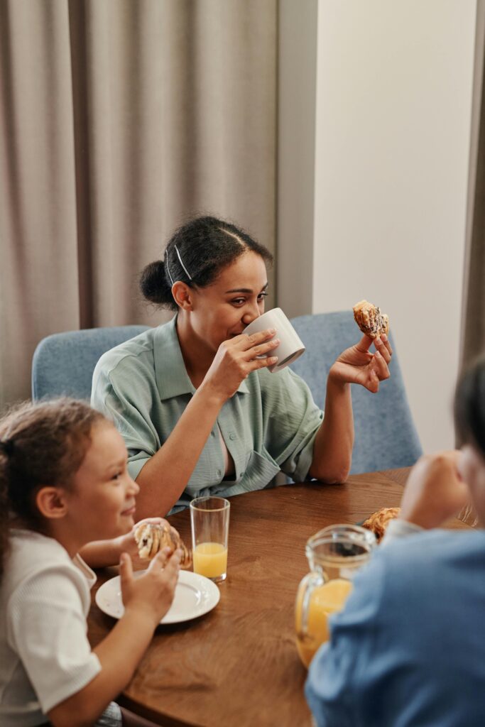 mãe tomando café da manhã com crianças sorrindo